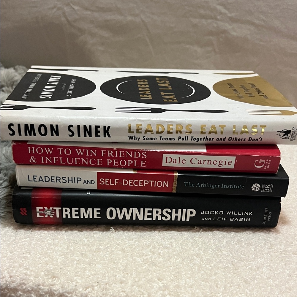 Stack of Leadership Books in White, Red, Black and Gold Covers